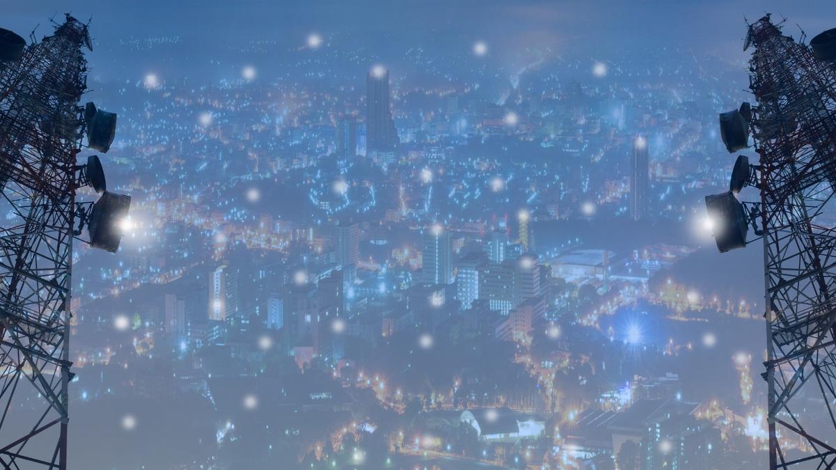 Telecom towers providing wireless network coverage over a city at night.